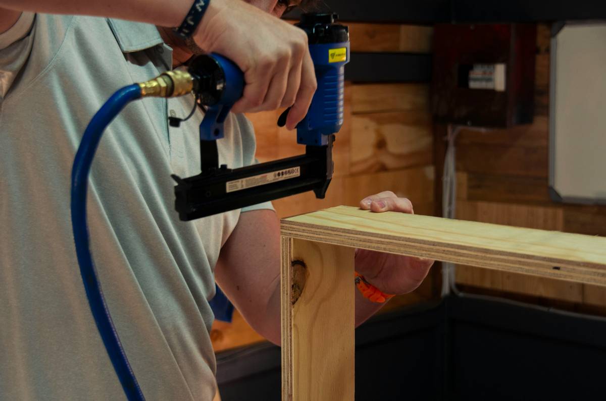 nail gun service repair showing disassembled internal components on a workbench